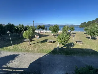 a park with trees and benches and a body of water at Sea Horizon I in Sada