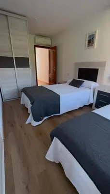two beds in a hotel room with two bedsskirts at PortoHome Ático in Portomarin
