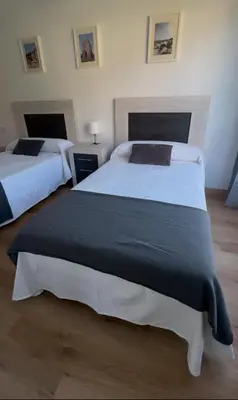 two beds in a hotel room with two beds at PortoHome Ático in Portomarin