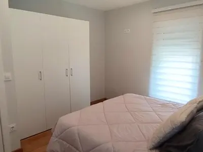 a bedroom with a bed and white cabinets and a window at Vivienda de uso Turístico Casa As Cachopas in Palas de Rei