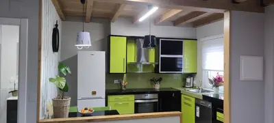 a kitchen with lime green and black cabinets at Vivienda de uso Turístico Casa As Cachopas in Palas de Rei