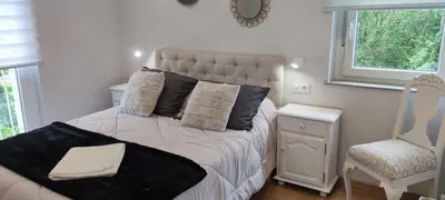 a bedroom with a bed and a chair and a window at Vivienda de uso Turístico Casa As Cachopas in Palas de Rei