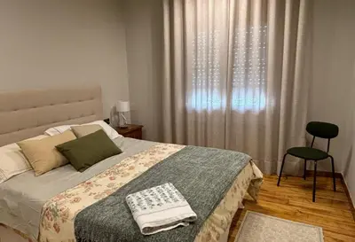 a bedroom with a bed and a chair and a window at Marujarural in Sober