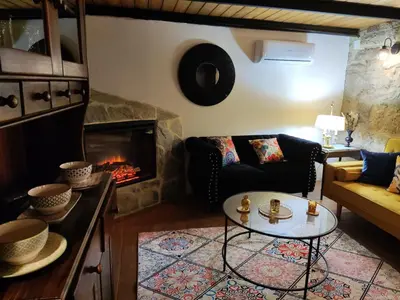 a living room with a couch and a fireplace at Xiravai-Ribeira Sacra in Peares