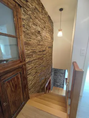 a stone wall next to a wooden door and stairs at Casa Sáner in Rábade