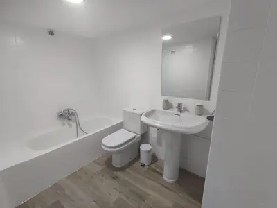 a white bathroom with a toilet and a sink at Casa Sáner in Rábade