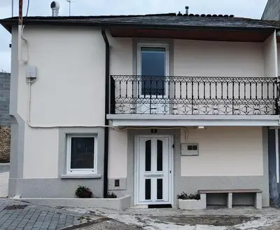a white house with a balcony and a door at Casa Sáner in Rábade