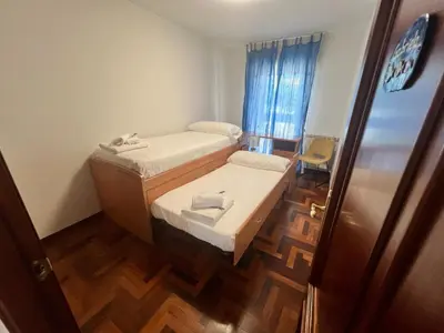 a small room with two beds and a wooden floor at Mártires de Carral in Santa María