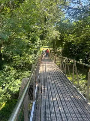 a group of people walking on a wooden bridge at Mártires de Carral in Santa María