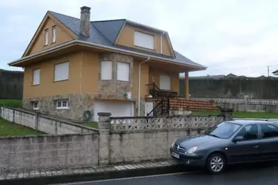 a car parked in front of a house at Preciosa casa en A Caridad in La Caridad