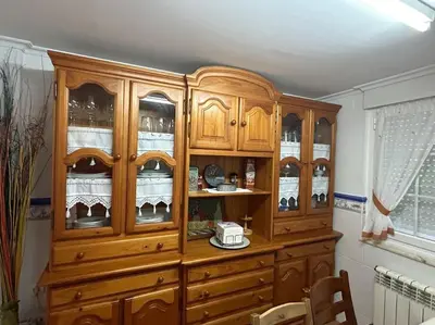 a wooden cabinet with glass doors in a room at Preciosa casa en A Caridad in La Caridad