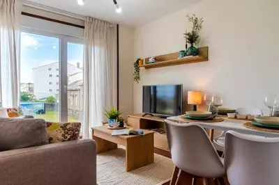 a living room with a table and a television at Apartamento de playa in San Ciprián