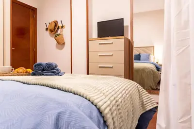 a bedroom with a bed and a dresser with a television at Apartamento de playa in San Ciprián