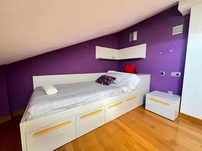 a bedroom with a bed with a purple wall at YourHouse Aldo in Ourense