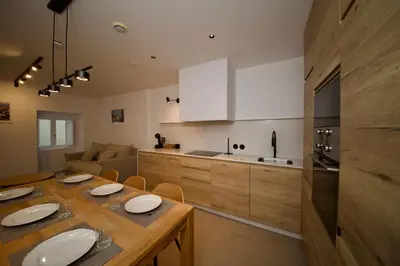a kitchen with a wooden table with plates on it at Amando Perez Suites in Ribadeo