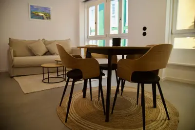 a table and chairs in a living room with a couch at Amando Perez Suites in Ribadeo
