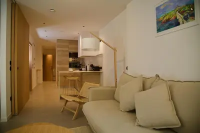a living room with a couch and a kitchen at Amando Perez Suites in Ribadeo