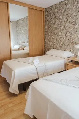 two beds in a hotel room with a mirror at Casa Rouco in Melide