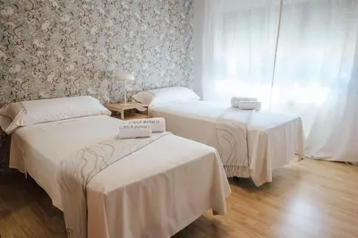 a room with two beds with white sheets at Casa Rouco in Melide