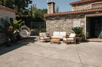 a group of chairs sitting outside of a building at Casa Rouco in Melide