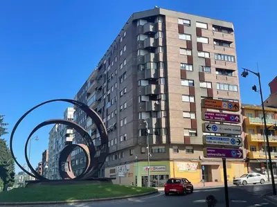 a tall building with a sculpture in front of it at Piso turistico Plaza del Cine in Ponferrada