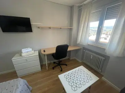 a room with a desk and a chair and a television at Piso turistico Plaza del Cine in Ponferrada