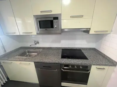 a kitchen with a sink and a microwave at Piso turistico Plaza del Cine in Ponferrada