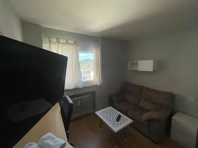a small living room with a couch and a window at Piso turistico Plaza del Cine in Ponferrada