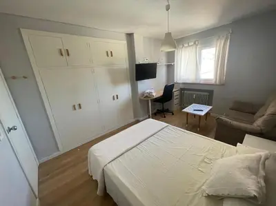 a bedroom with a bed and a couch and a desk at Piso turistico Plaza del Cine in Ponferrada