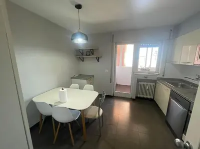 a small kitchen with a white table and chairs at Piso turistico Plaza del Cine in Ponferrada