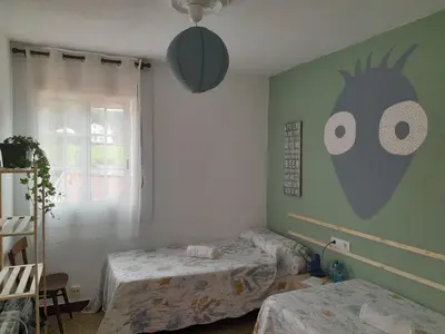 a bedroom with two beds with eyes on the wall at Casa de Amigos in Picaraña
