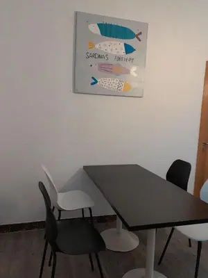 a table and chairs in a room with a picture on the wall at Casa de Amigos in Picaraña