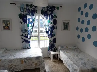 a bedroom with two beds and a window at Casa de Amigos in Picaraña