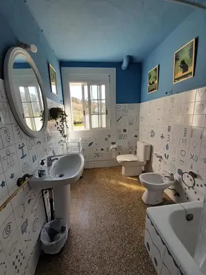 a bathroom with two sinks and two toilets at Casa de Amigos in Picaraña