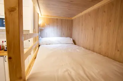 a small bed in a small room with wooden walls at Soños de Compostela in Santiago de Compostela