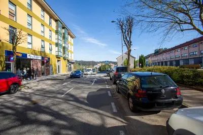 a street with cars parked on the side of the road at Soños de Compostela in Santiago de Compostela