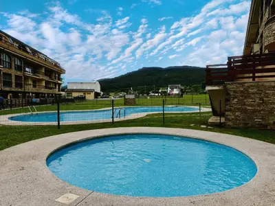 a large blue swimming pool next to a building at Apartamento Herosa 1 Spa in Barreiros