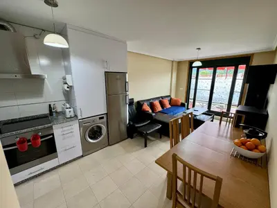 a kitchen and living room with a table and a dining room at Apartamento Herosa 1 Spa in Barreiros