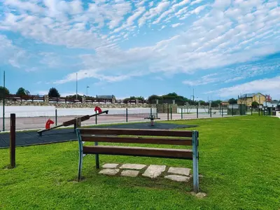 a park bench sitting on the grass in a field at Apartamento Herosa 1 Spa in Barreiros