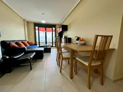 a living room with a table and chairs and a couch at Apartamento Herosa 1 Spa in Barreiros