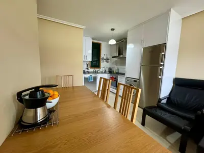 a kitchen and living room with a table and a couch at Apartamento Herosa 1 Spa in Barreiros