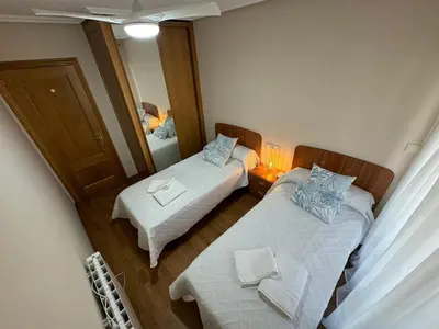 a small room with two beds and a mirror at Apartamento VILLA ANDRES in Villadaíde