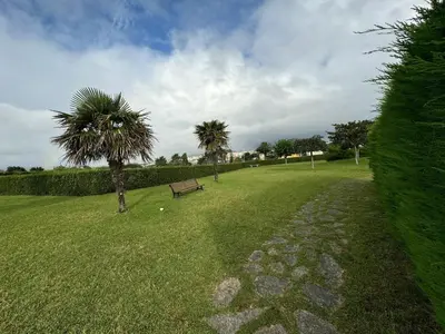 a park with a bench and two palm trees at Apartamento VILLA ANDRES in Villadaíde