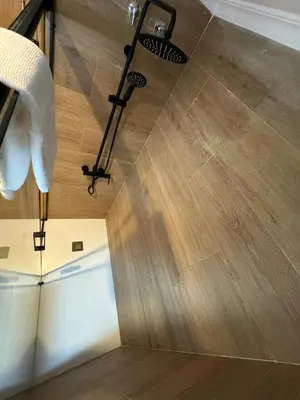 a bathroom with a shower with a wooden floor at Apartamento VILLA ANDRES in Villadaíde