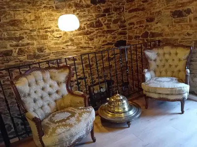 two chairs in a room with a stone wall at Casa do Outeiro in Friol