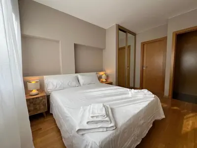 a bedroom with a white bed with towels on it at YourHouse Lagoa in Ourense