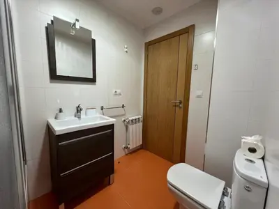 a bathroom with a sink and a toilet and a mirror at YourHouse Lagoa in Ourense
