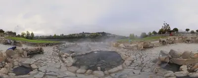 a group of people standing around a hot spring at YourHouse Lagoa in Ourense