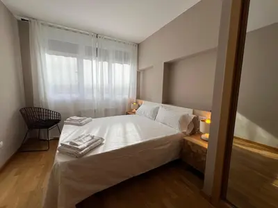 a bedroom with a bed with white sheets and a window at YourHouse Lagoa in Ourense
