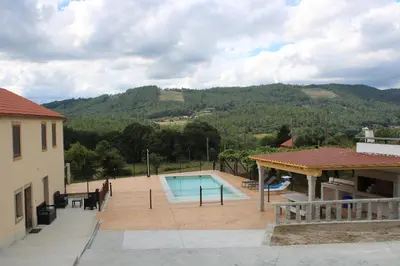 a house with a swimming pool next to a mountain at A de Jose Luis in Reis